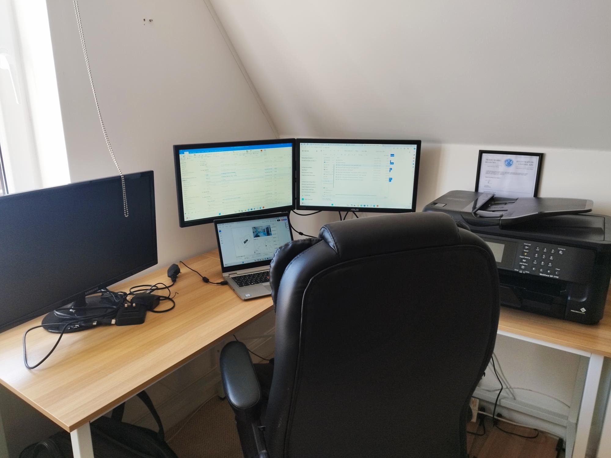 Home-office work corner with desk, dual monitors, laptop, printer and chair