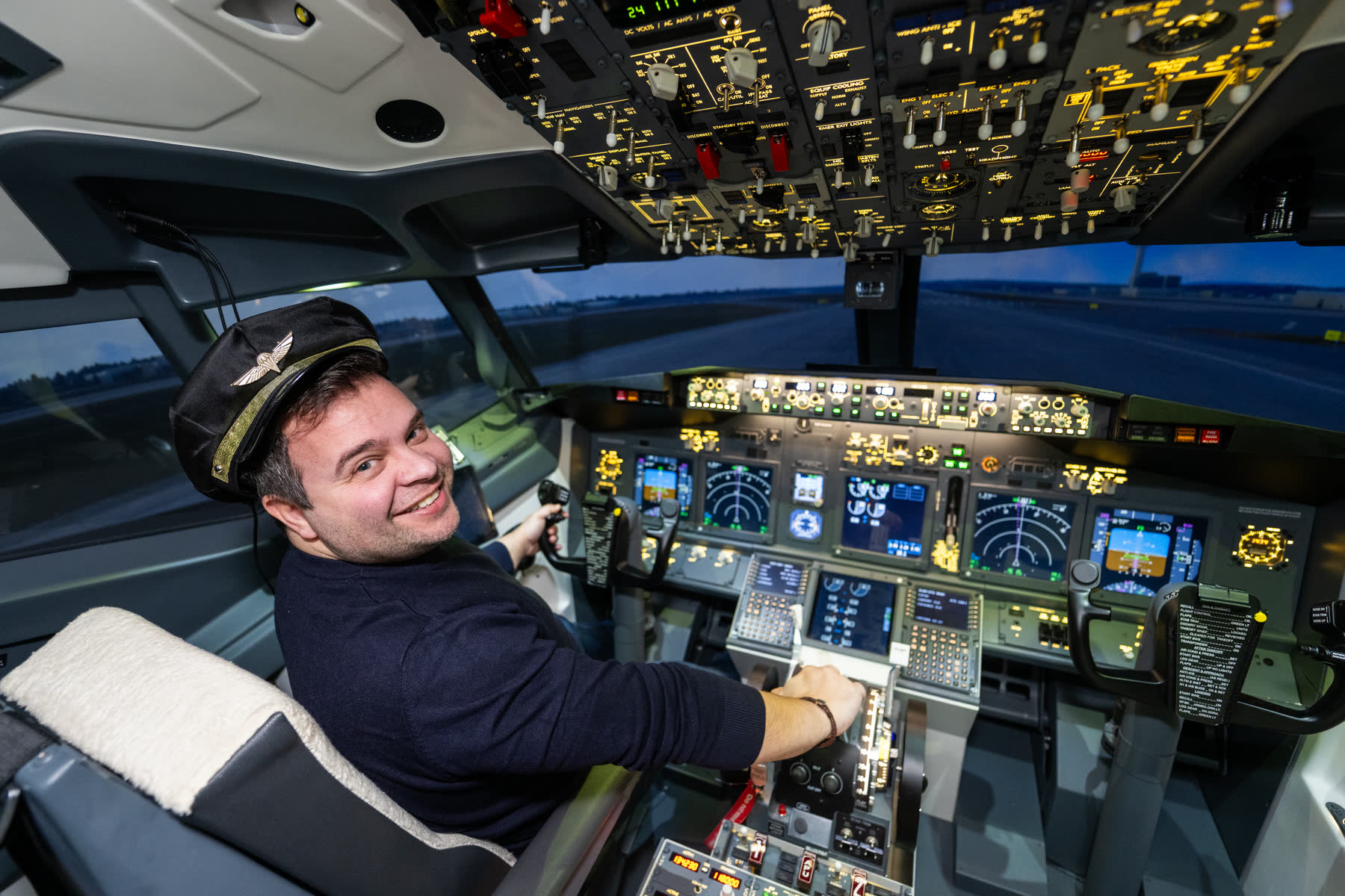 Solo pilot at the controls, smiling in the left seat with the full 737 flight deck behind