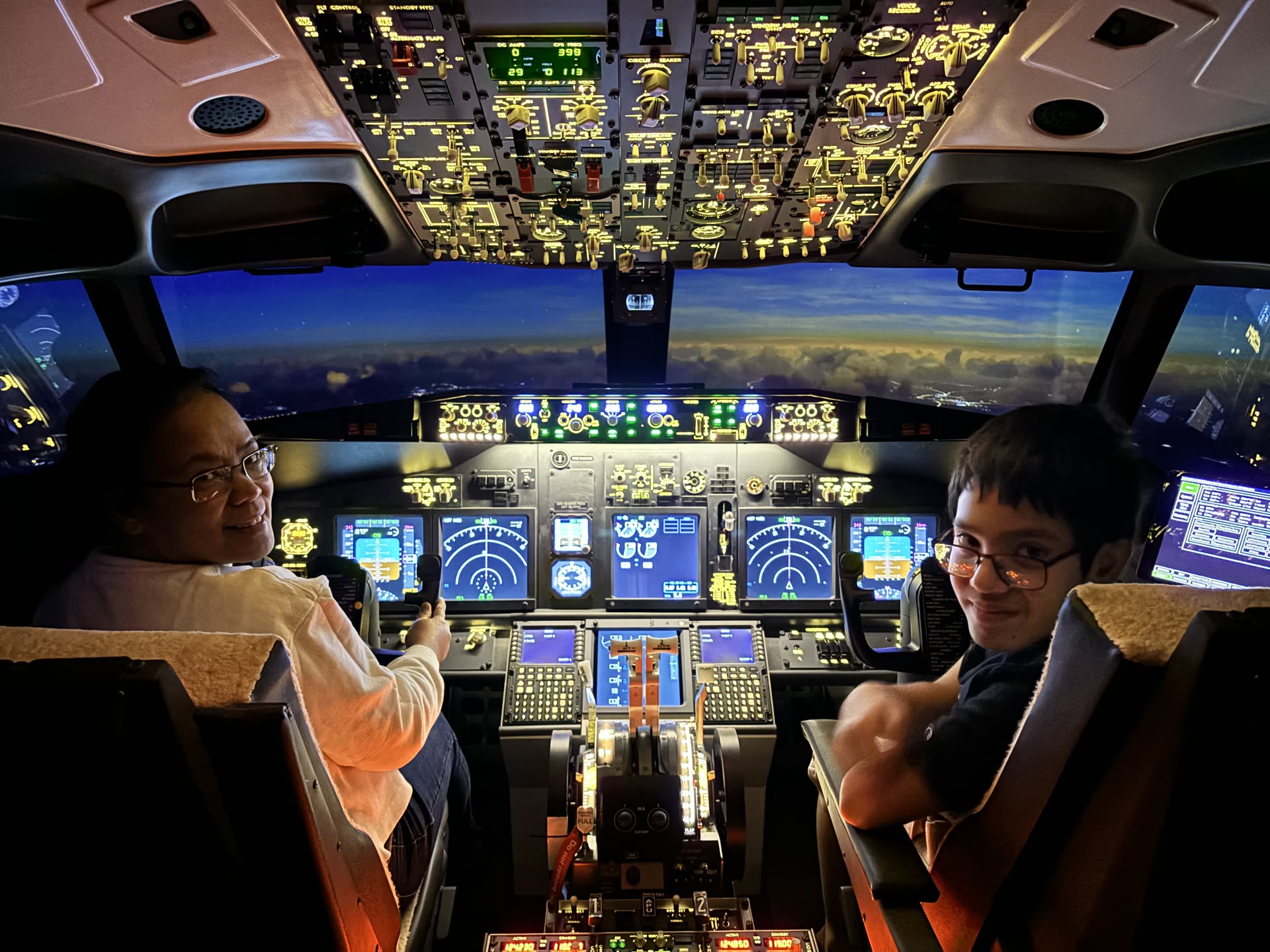 Boeing 737-800NG cockpit lit by sunset, screens alive